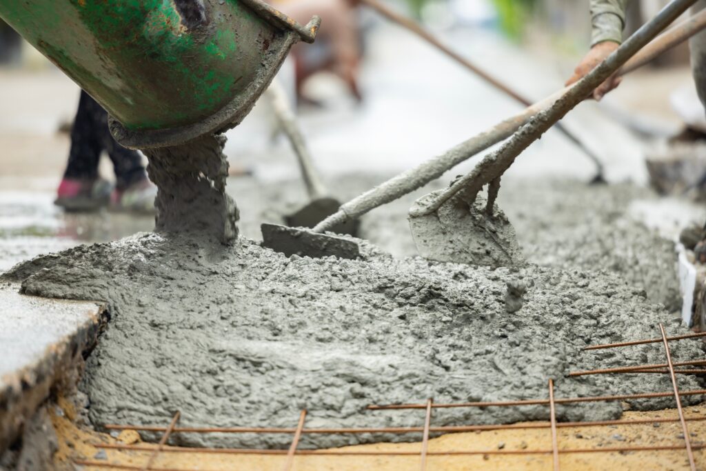 people pouring cement into hole